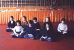 Children from the elementary school meditating in lotus position .